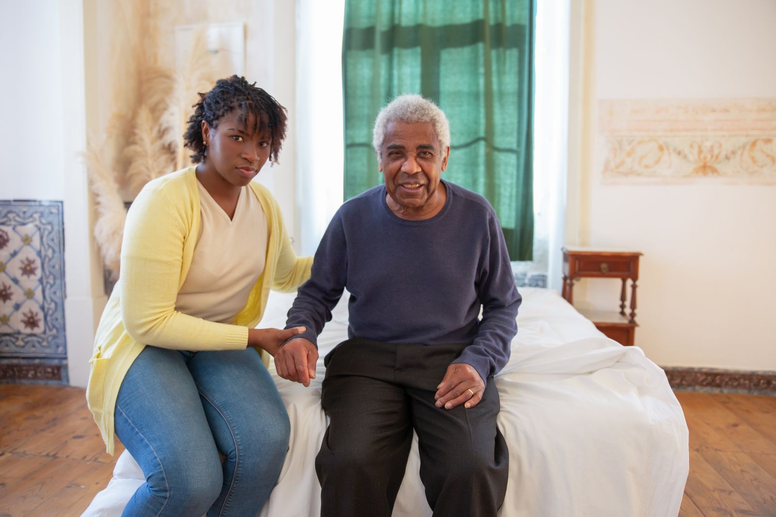 Patient care attendant assisting an elderly patient at home